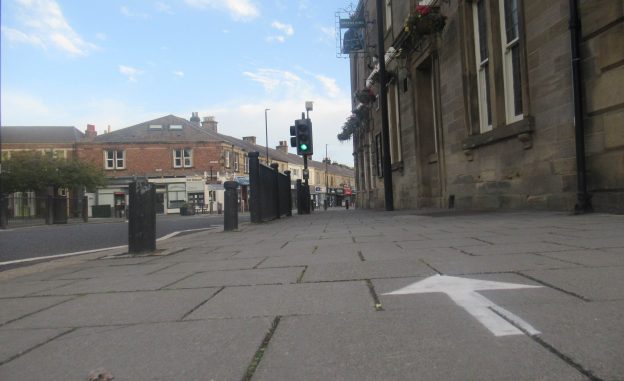 Picture of the pavement by The County with a painted direction arrow
