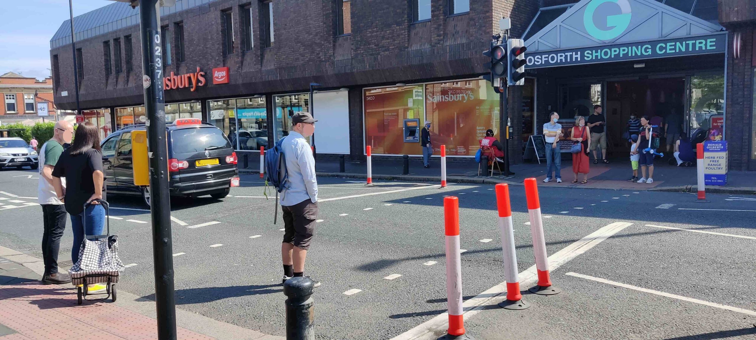 Picture of people crossing Gosforth High Street next to Trinity Church